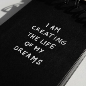 A black chalkboard with a message that reads, I am creating the life of my dreams.
